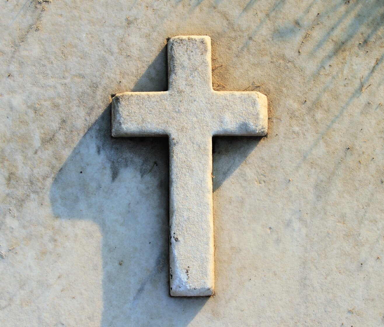 A stone cross casting a shadow
