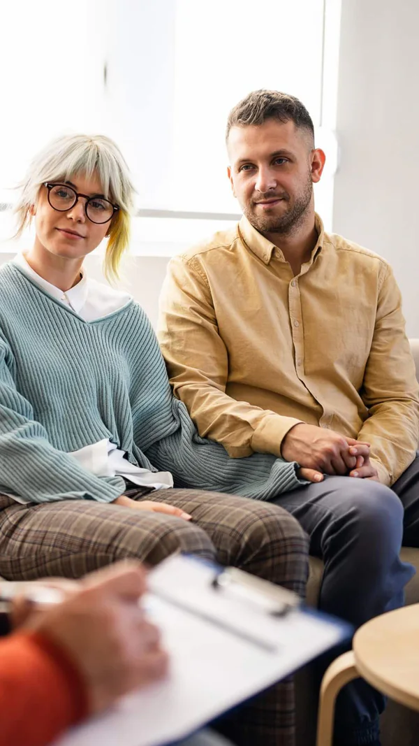 A couple meeting with a therapist in person