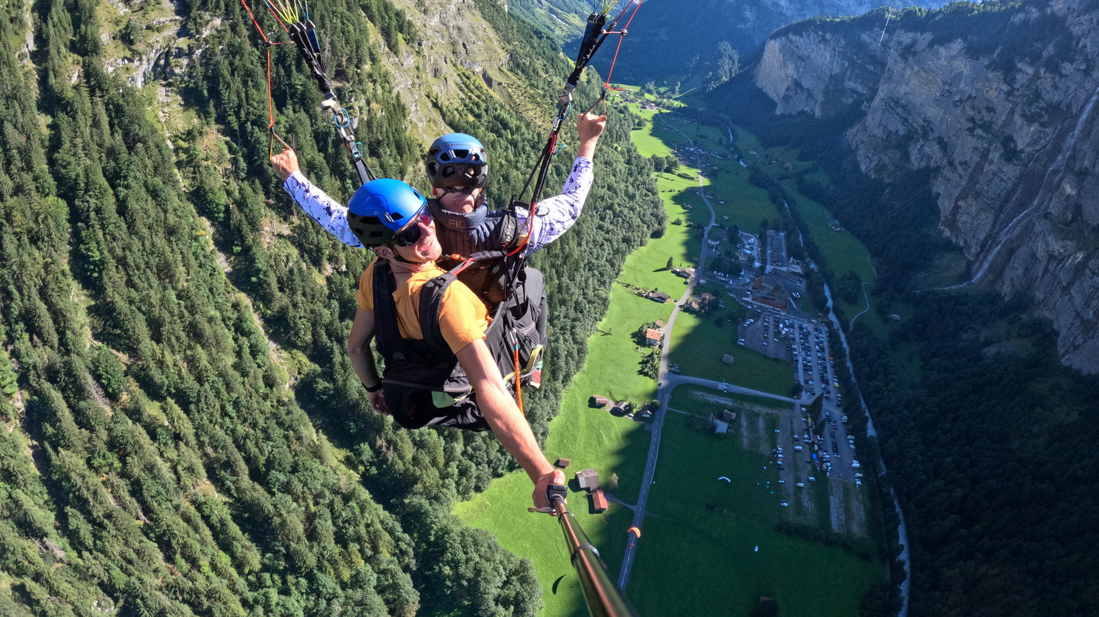 Dr. Peter Robbins tandem paragliding above a mountain valley.